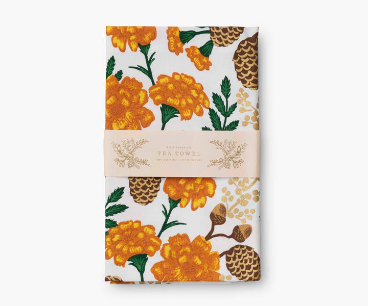 Folded tea towel with orange and brown floral pattern with paper display band.