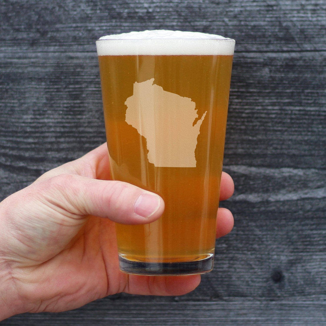 Hand holding a pint glass with a Wisconsin state etching and filled with bear. 