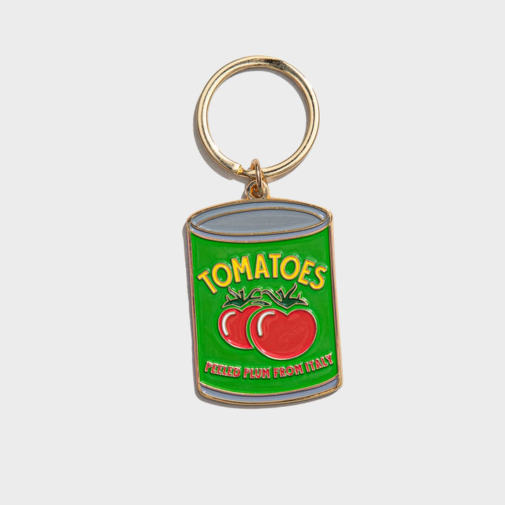 Two red tomatoes on a green can label with yellow and red text and gold keyring.