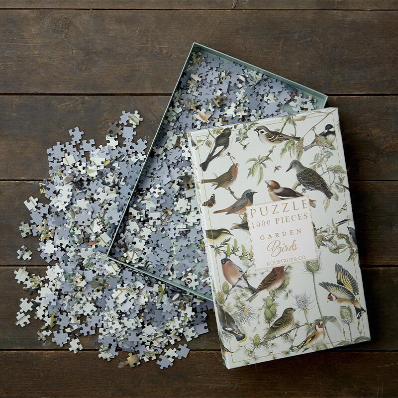 Puzzle box open with puzzle pieces on inside and outside of box.