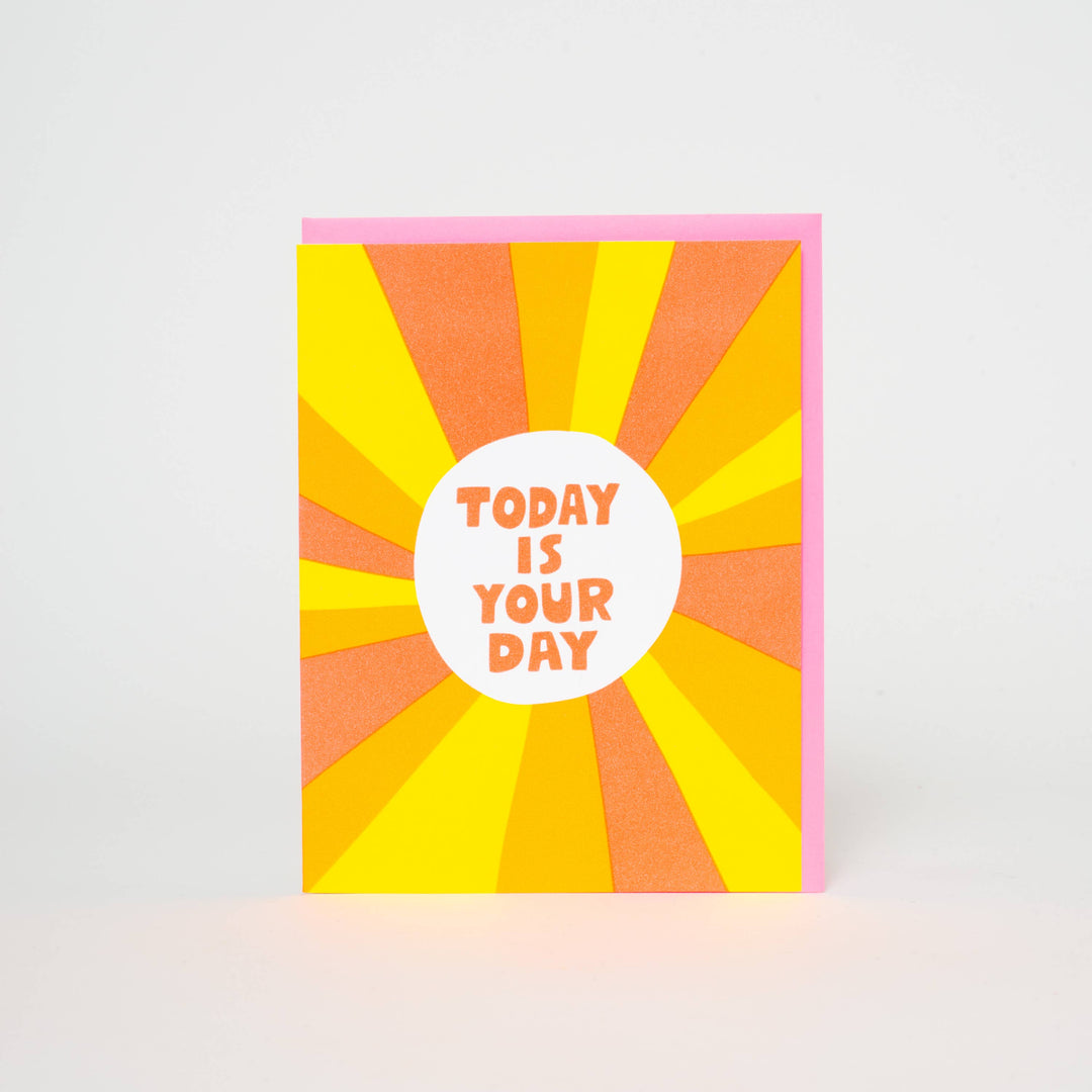 Orange text on white background in the center of yellow, orange and gold sunbeams.