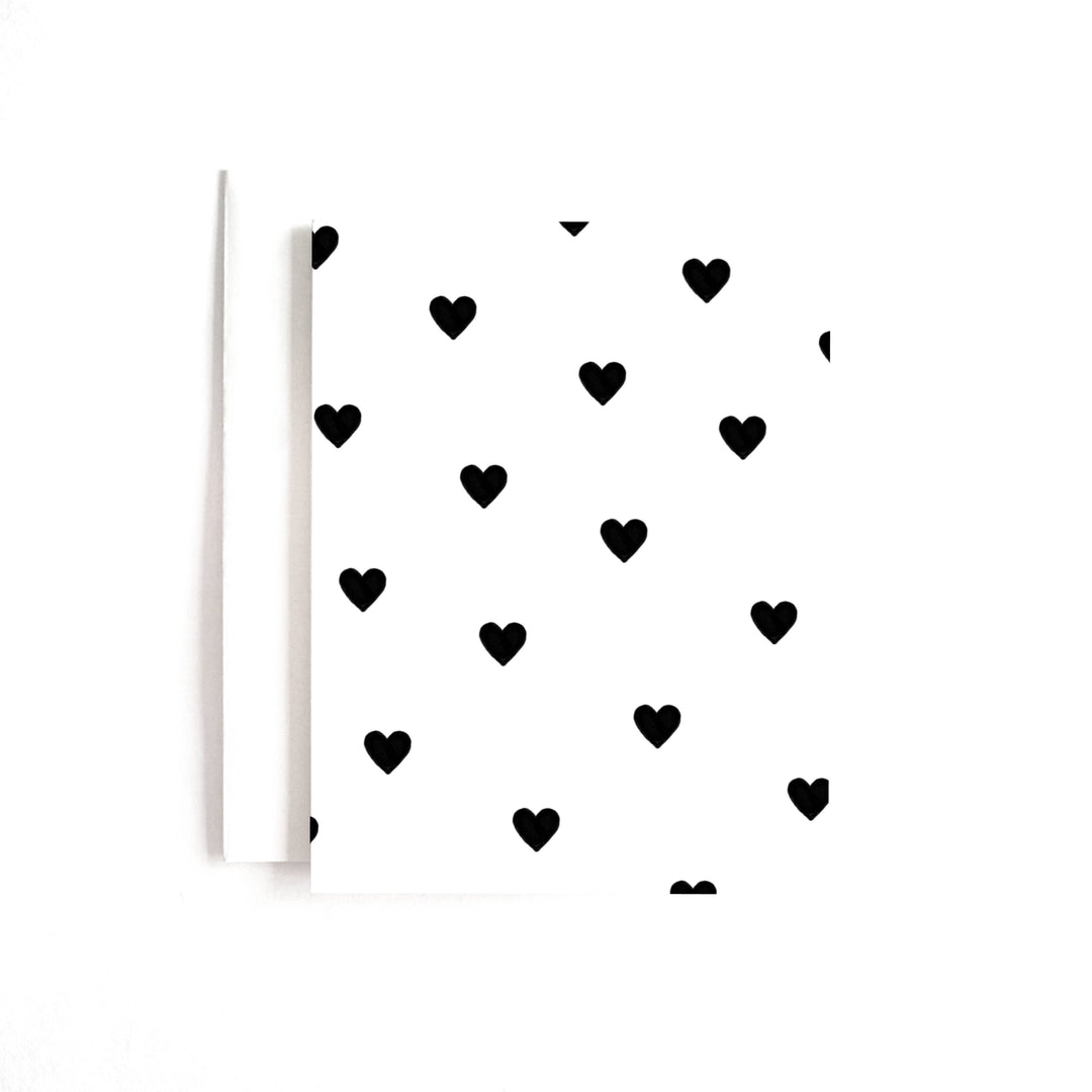 Rows of black hearts on white cardstock.