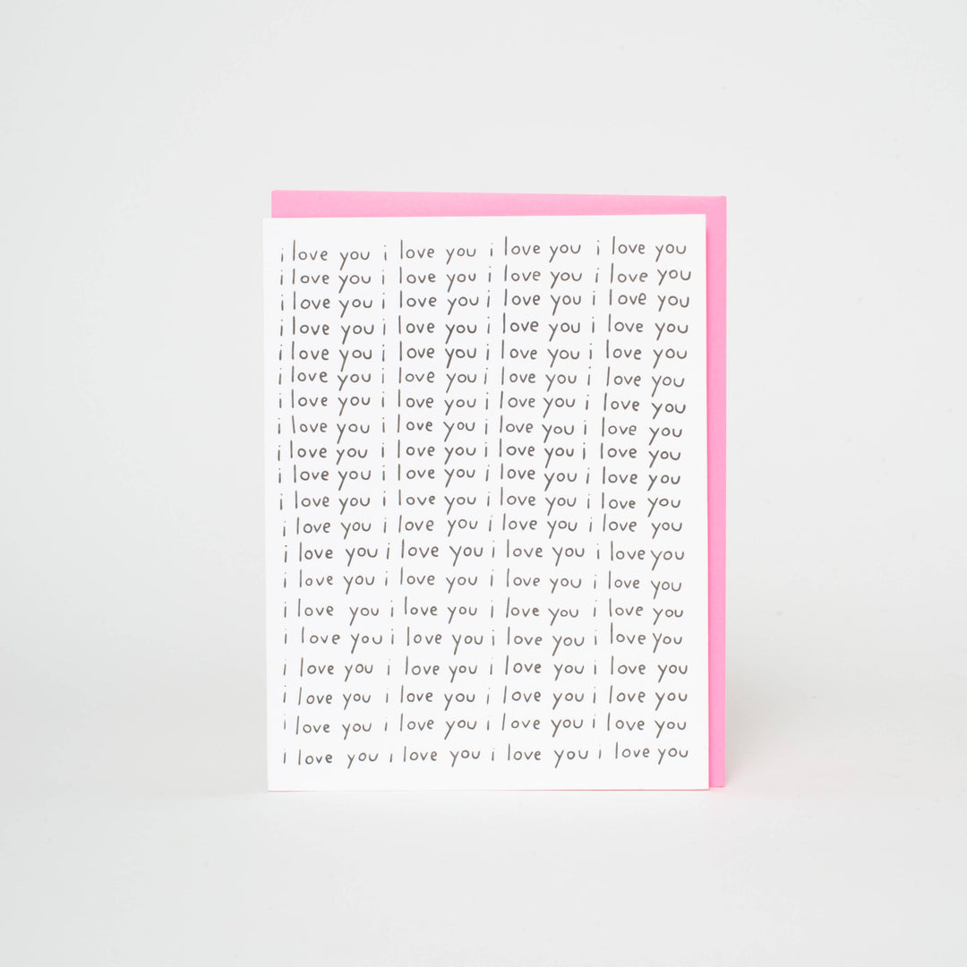 "I love you" repeated 80 times in black lowercase hand drawn font on white card stock.