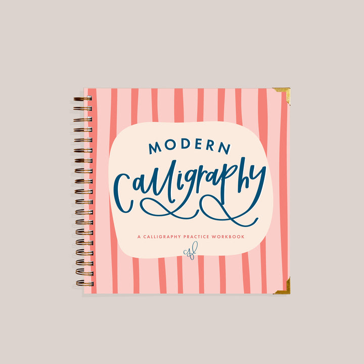 Cover of the spiral-bound calligraphy practice workbook titled 'Modern Calligraphy' on a light pink and coral striped cover with a cream central label.