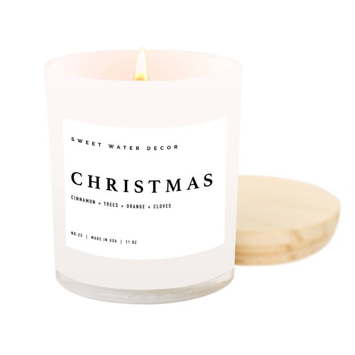 Christmas soy candle in a white  matte glass container with wooden lid. Scent is cinnamon, trees, orange and cloves.