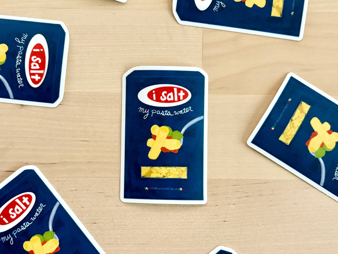 A sticker in the shape of a pasta box. The label "I salt" is in a red circle and "my pasta water" on the blue box. A spoon with pasta decorates the box and a window below it shows the pasta.