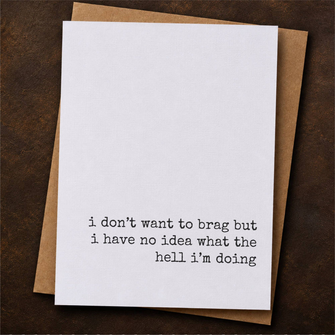 A white greeting card with black typewriter-style text reading 'i don't want to brag but i have no idea what the hell i'm doing', placed on top of a brown kraft envelope.