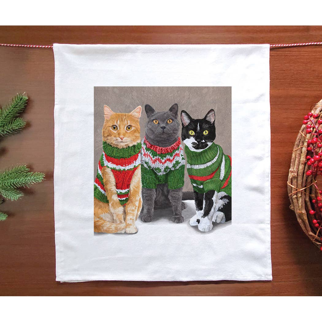 Cotton towel with three cats -- a tabby, a gray, and a tuxedo -- wearing red and green Christmas sweaters. 