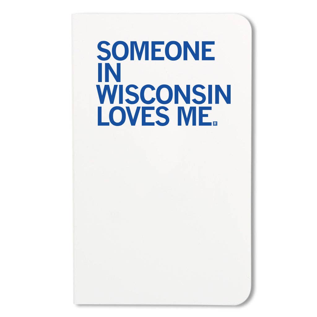 A white notebook with rounded corners featuring the phrase 'SOMEONE IN WISCONSIN LOVES ME.' printed in bold blue text on the front cover.