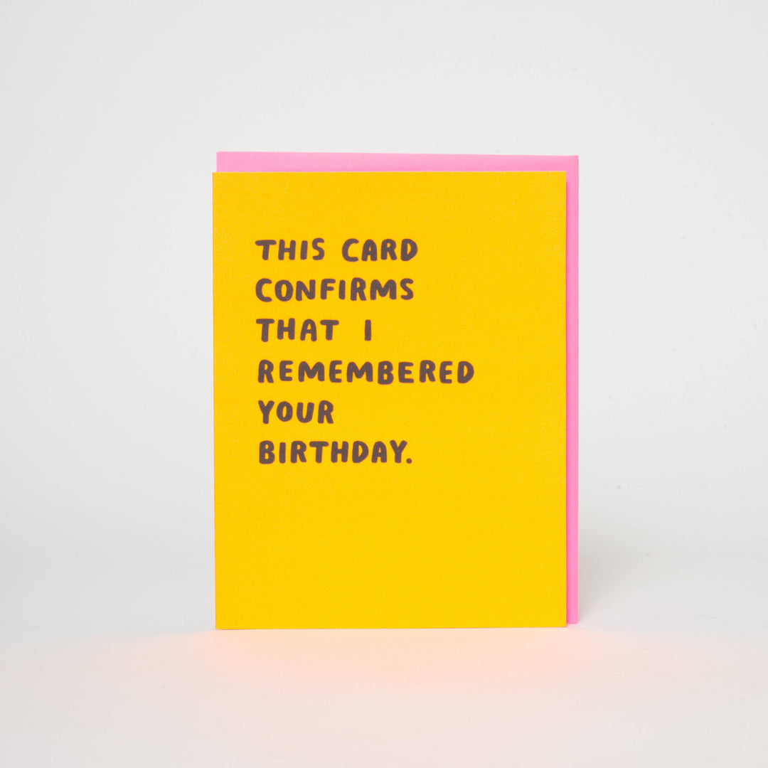 Purple text in san-serif font and all capital letters on yellow cardstock with pink envelope