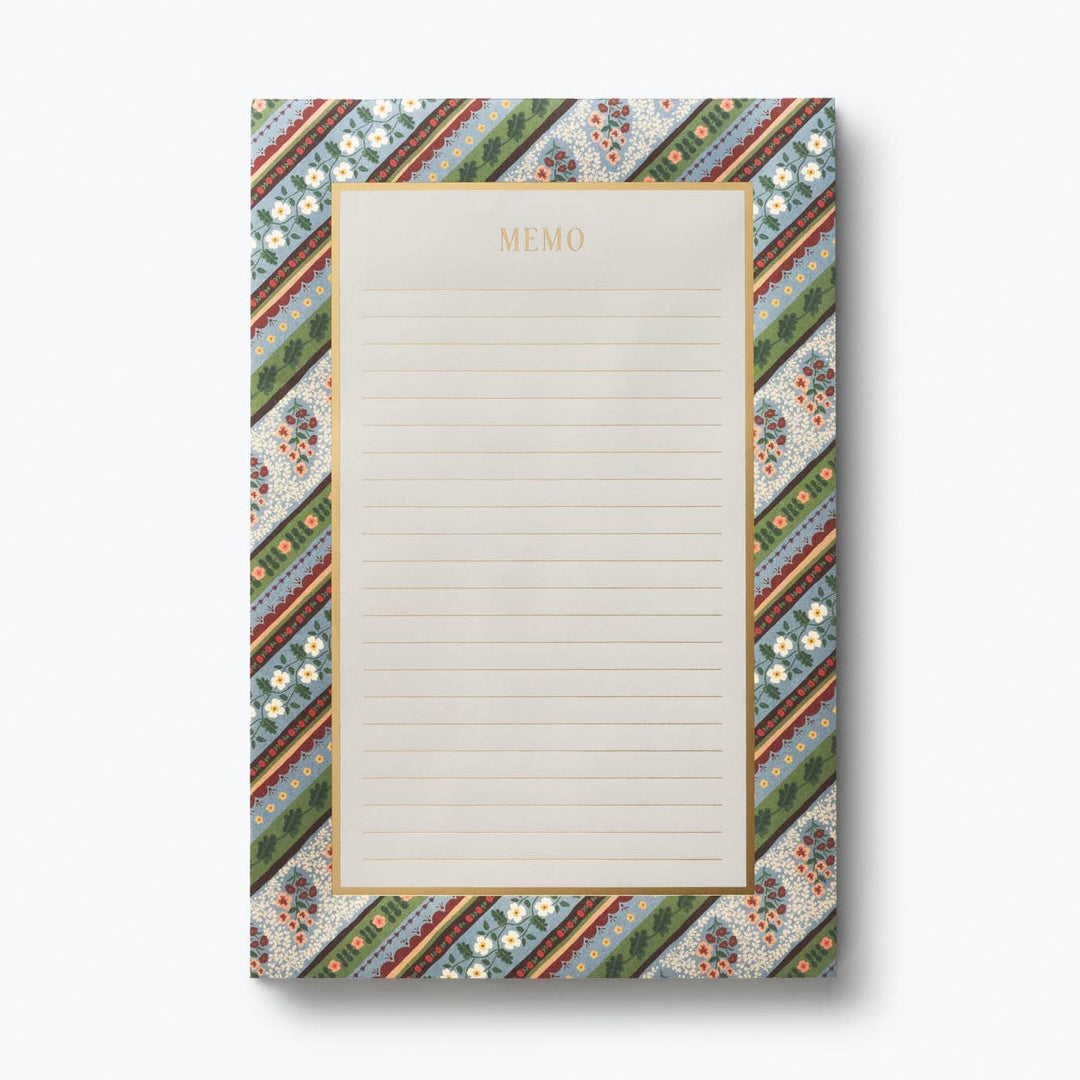 Memo pad with a border of diagonal strips of small flowers in blues and greens, with the writing area defined with a gold border and gold lines and the word 'memo' at the top.