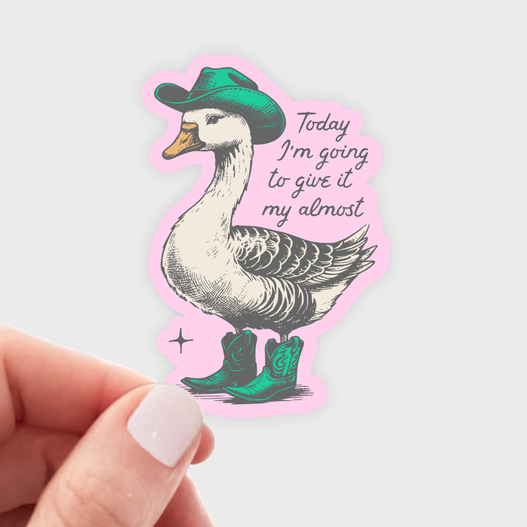 Hand holding a aticker with a duck wearing a green hat and cowboy boots, wit the text 'Today I'm going to give it my almost'