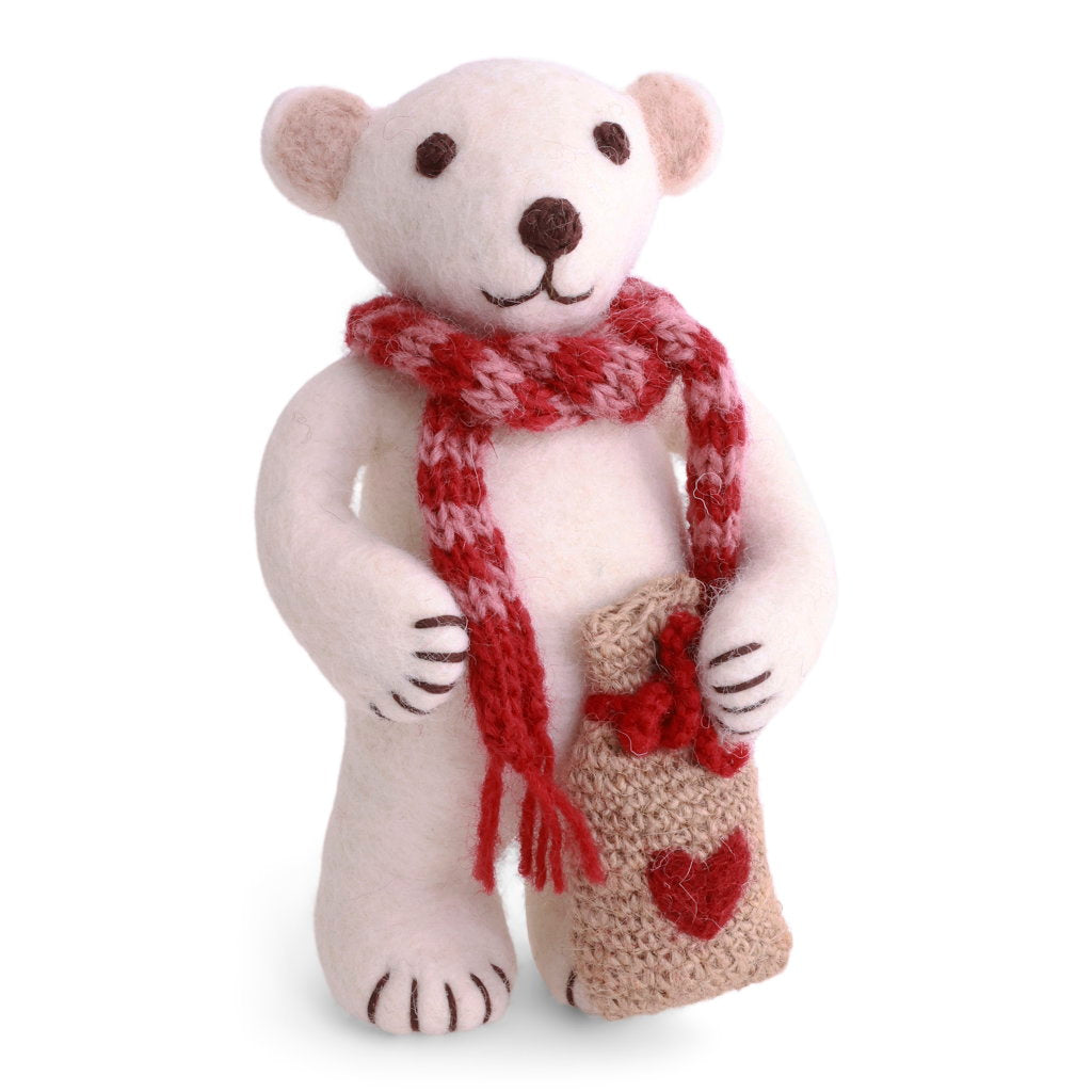A white felt polar wearing a red and white knit scarf and holding a beige burlap sack with a red heart.