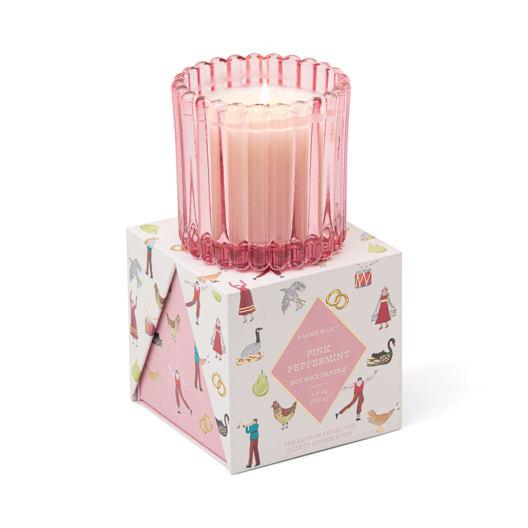Pink candle in a decorative box with illustrations 