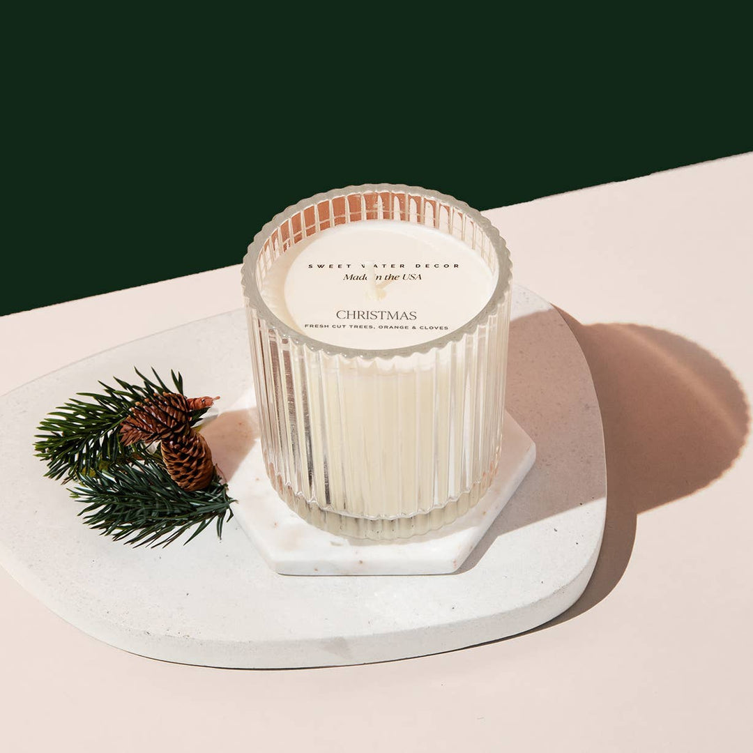 Christmas soy candle in a fluted clear glass container. 