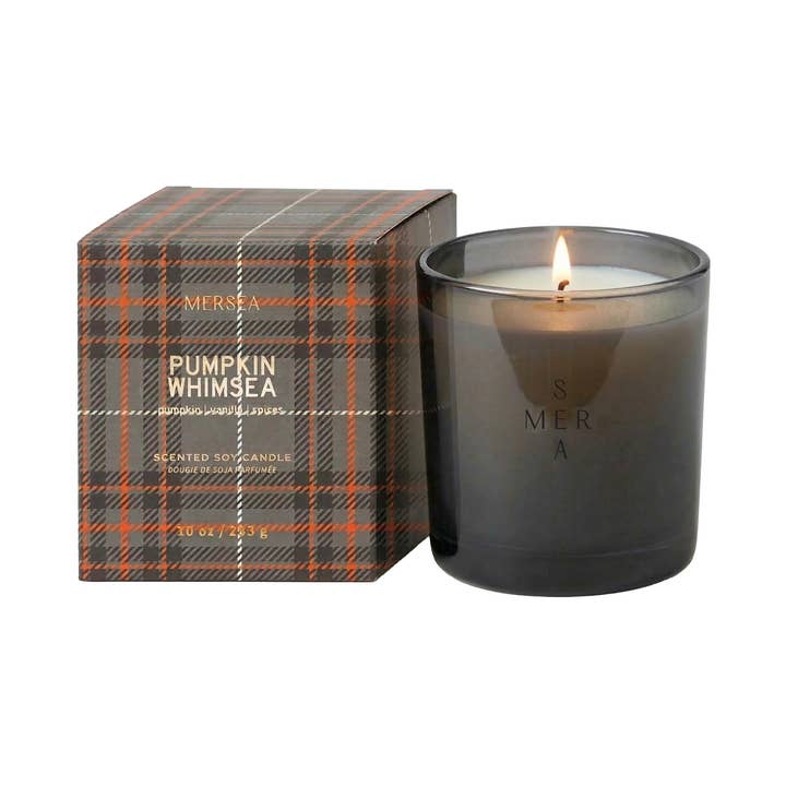 Mersea Fireside Flannel scented soy candle in a dark gray glass jar next to its plaid packaging box.