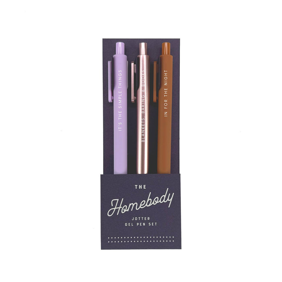 Lavender, silver and brown pens, each with descriptive text, in a black packaging sleeve labeled 'The Homebody Jotter Gel Pen Set"