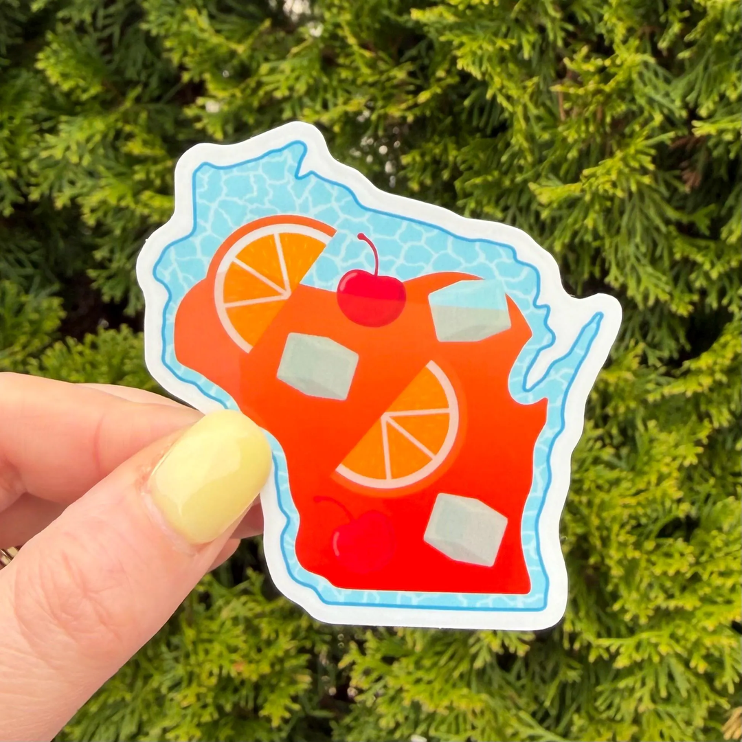 Sticker shaped like the state of Wisconsin, featuring a colorful illustration of a brandy old fashioned with orange slices, cherries, and ice cubes.