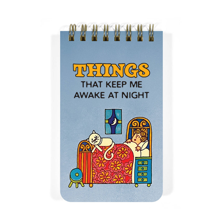 Blue notebook cover with illustration of a cat at the feet of a person in bed below the text 'THINGS THAT KEEP ME AWAKE AT NIGHT.'