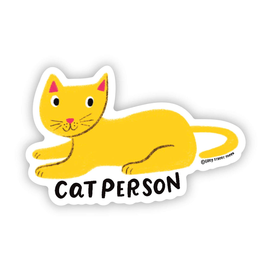 Cat-shaped sticker with a yellow cat with pink ears and nose and the text 'cat person' in black.