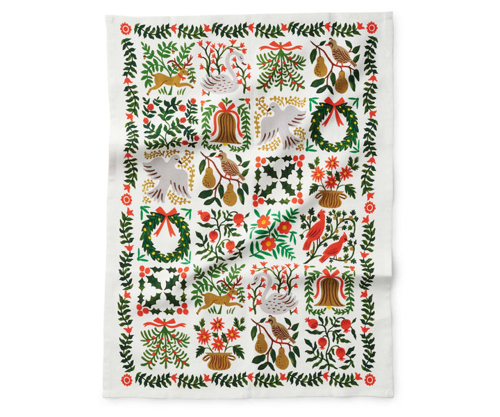Tea towel with floral and nature-themed illustrations of  a swan, deer, partridge in a pear tree, persimmons and flowers fully open.