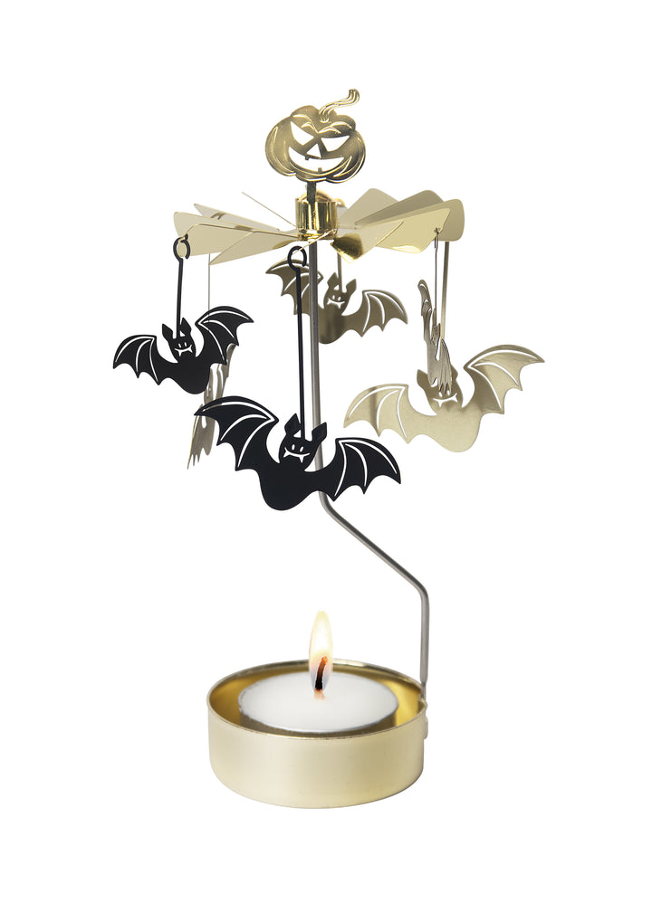 Tea light in a gold-colored holder with vertical arm supporting a carousel of bats and a spooky pumpkin on top.