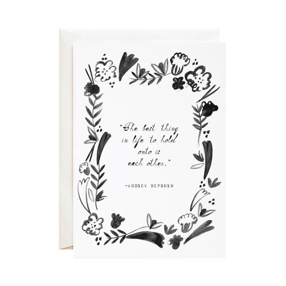 Black illustration and text on a white card. The illustration of flowers and leaves frames the text.