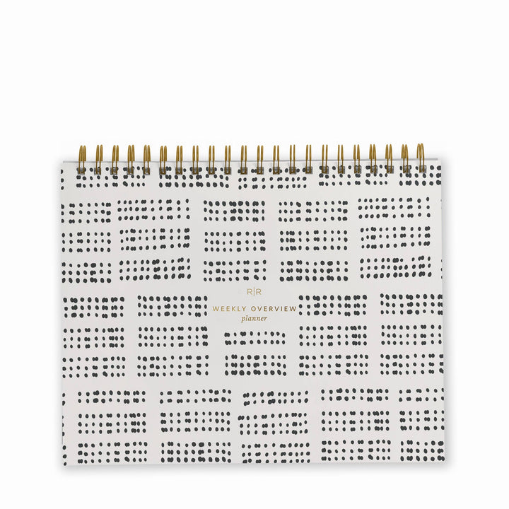 Cover of weekly planner with a black dotted grid pattern and gold spiral binding at top.