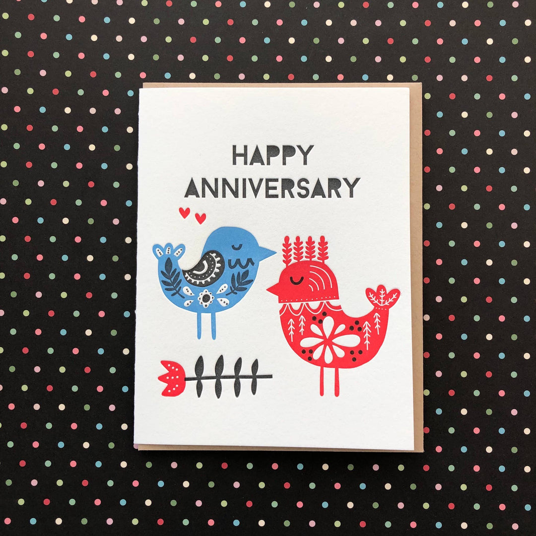 Hand drawn red and blue birds and a flower with black text on white cardstock