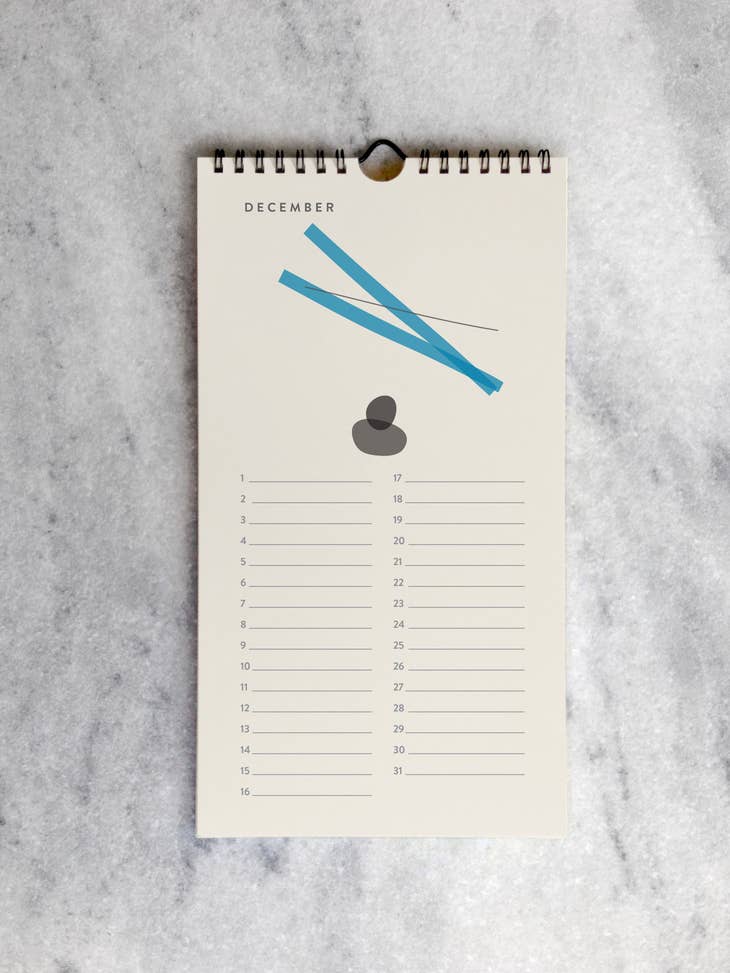 The page for December with a drawing of two two blue bars intersecting at one end, next to to gray intersecting ovals , above lines for each day in the month.