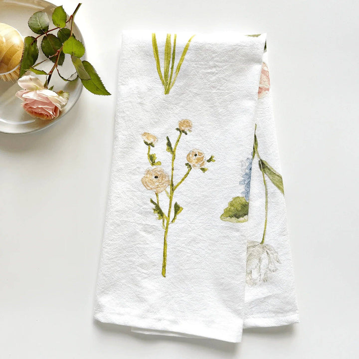 Kitchen towel with watercolor illustration of a stem of a light rose flower.