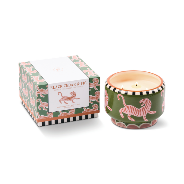 Ceramic candle holder with tiger design next to tiger decorated box with 'Black Cedar & Fig' label. 