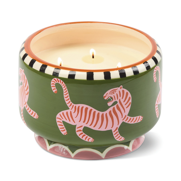 Four lit wicks in a ceramic candle holder with tiger design on a green background with black and white trim around the top.