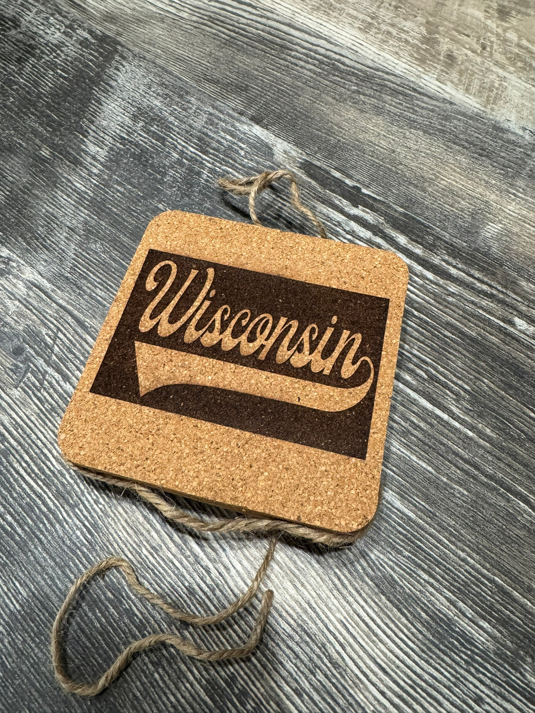 Cork coasters with the word Wisconsin in a cursive script on them.