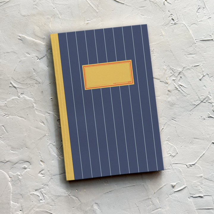 A notebook with a navy blue cover featuring thin white vertical pinstripes, a mustard yellow spine, and a blank mustard yellow label on the front.