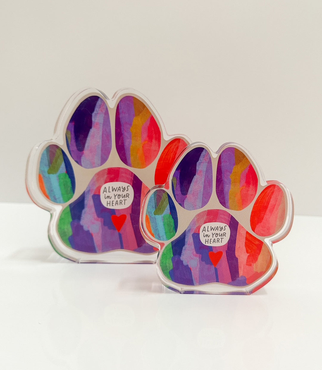 Two colorful paw-shaped plaques with 'Always in your heart' text in the center and above a small red heart.