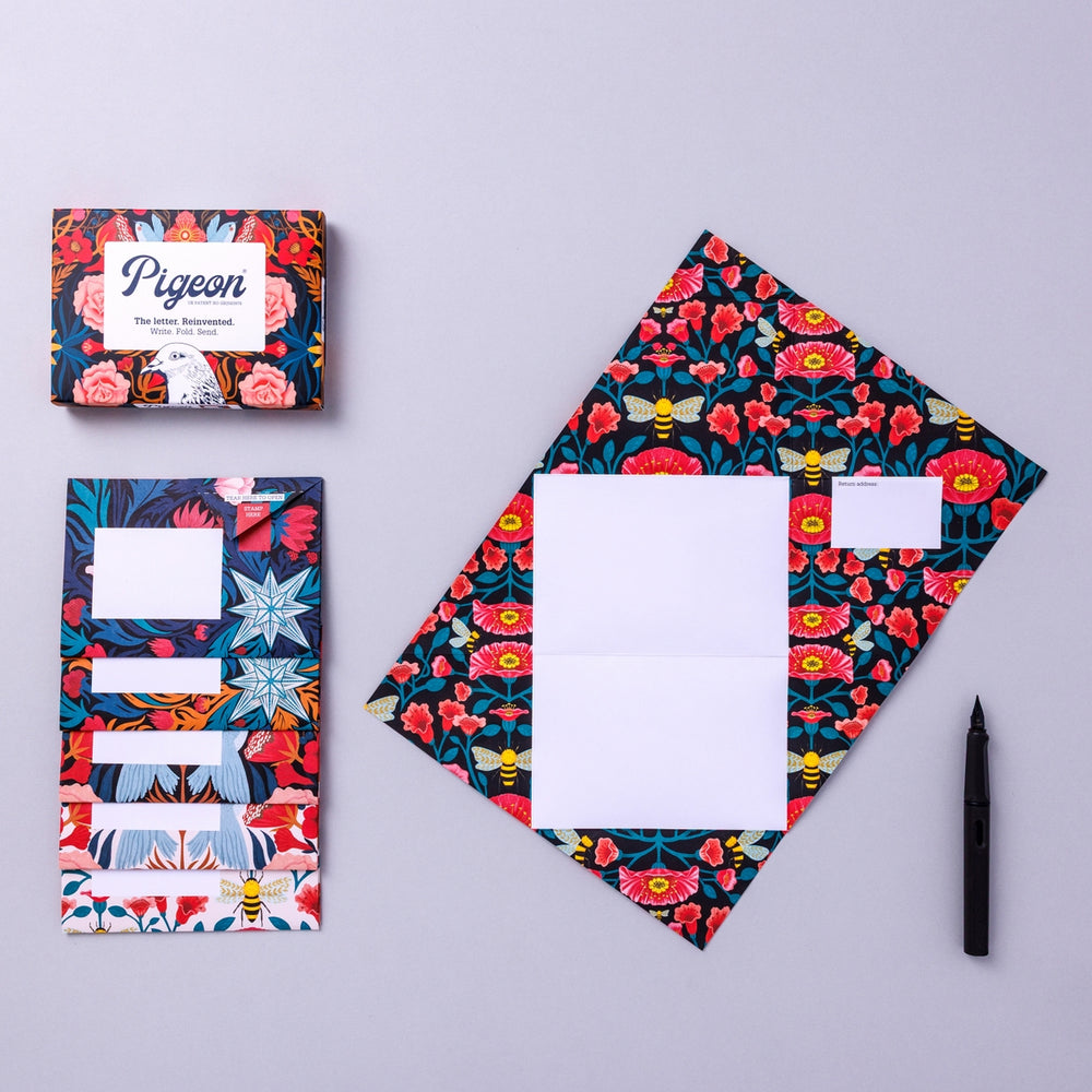 Writing set opened to show five envelopes, each with a different design, and the sixth unfolded to show the writing area, all decorated with bright flowers.
