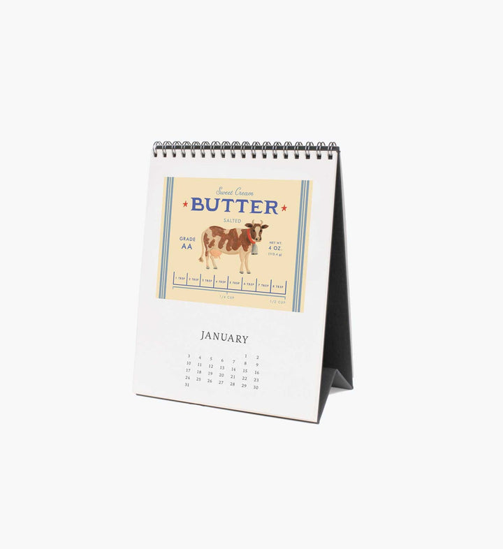 Calendar page for January with a butter wrapper with an illustration of a cow.