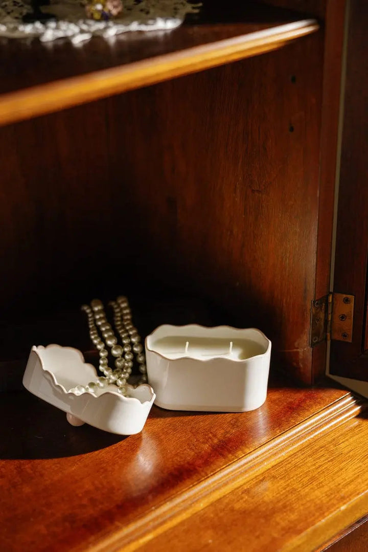 Lit candle in a bookshelf, with the top placed next to it.