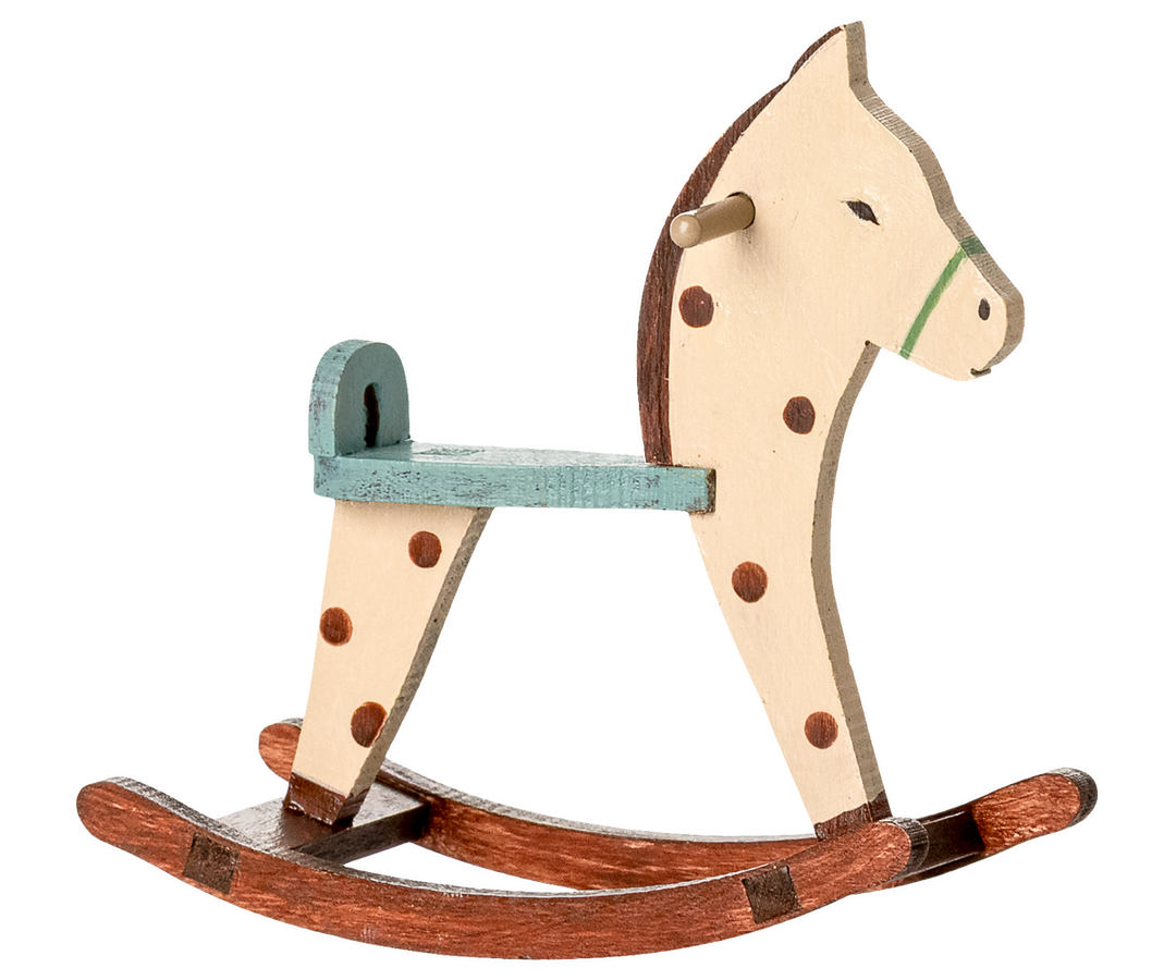 Wooden rocking horse with a white face, brown spots, and a green seat.