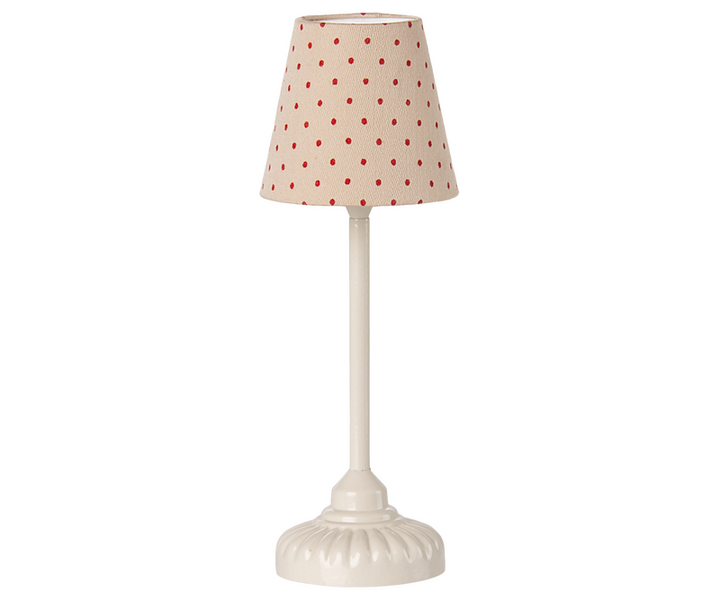 White floor lamp with a beige lampshade with red polka dots. 