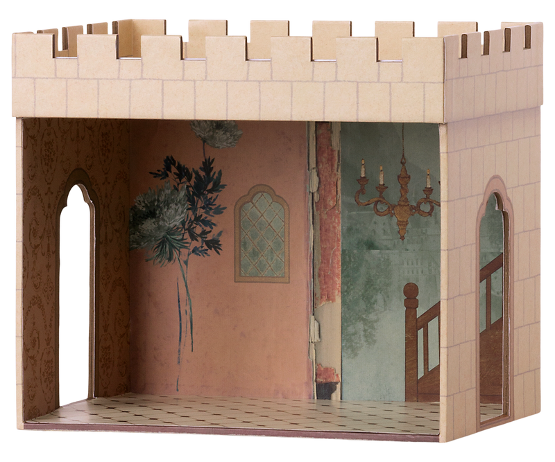 Castle hall with one side open to show the painted interior with pink wall decorated with a plant, a chandelier, and tile floor. There are two openings on either side and a roof with the cutouts that resemble teeth.