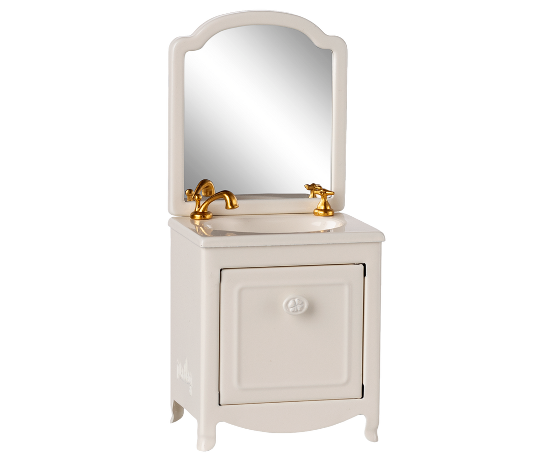 White vanity with mirror and gold fixtures.