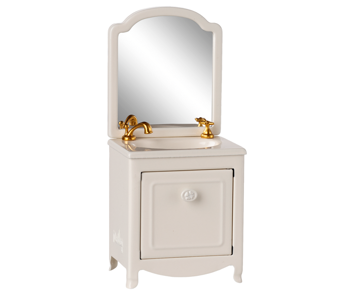White vanity with mirror and gold fixtures.