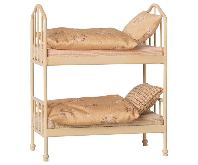 Bunk bed with a cream-colored metal frame, styled with beige floral bedding and pillows.