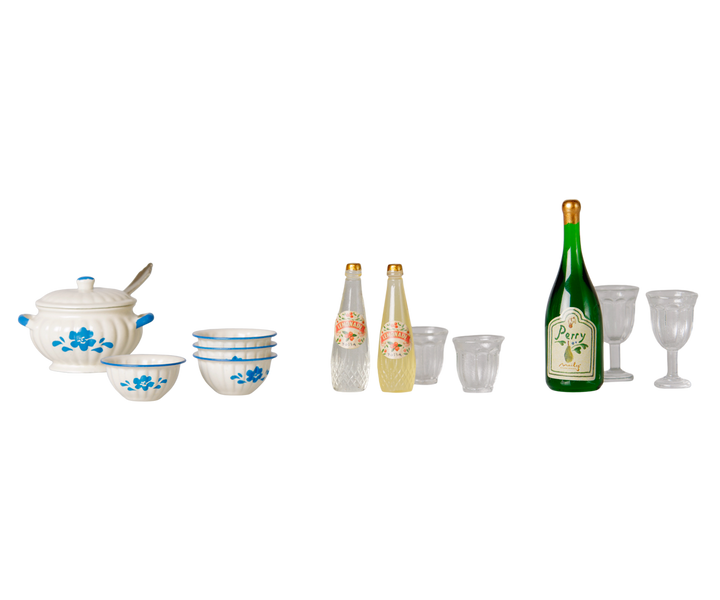 A miniature cooking set featuring a white ceramic soup pot and four bowls in a blue floral patterns, two clear bottles and glasses for the children mice beverage and  a wine bottle and clear glasses for adult mice.