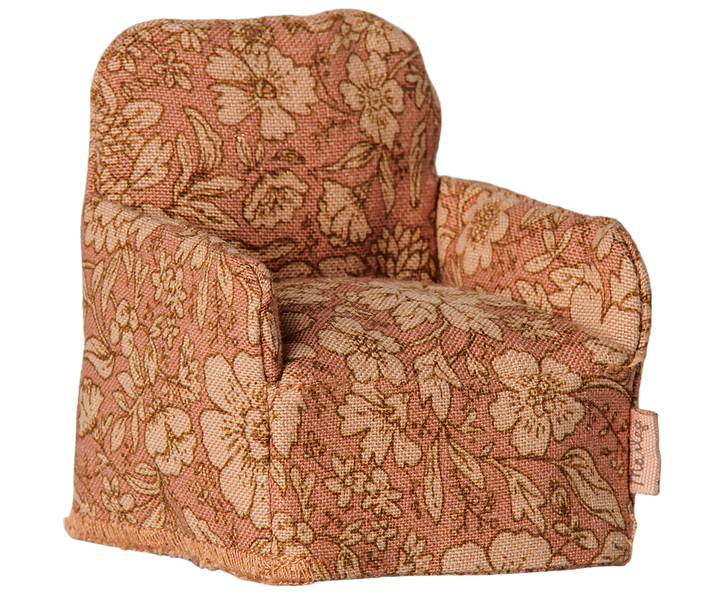 Upholstered armchair with a dusty rose and beige floral pattern.