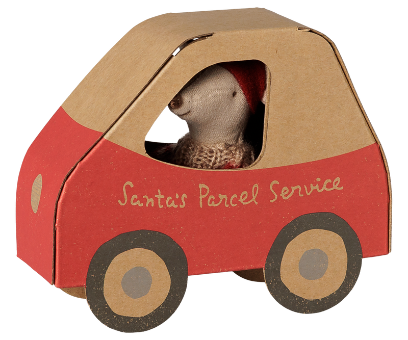 Little sister mouse inside the cardboard car with a beige top, red body, beige wheels with black rims, and 'Santa's Postal Service' on the side.
