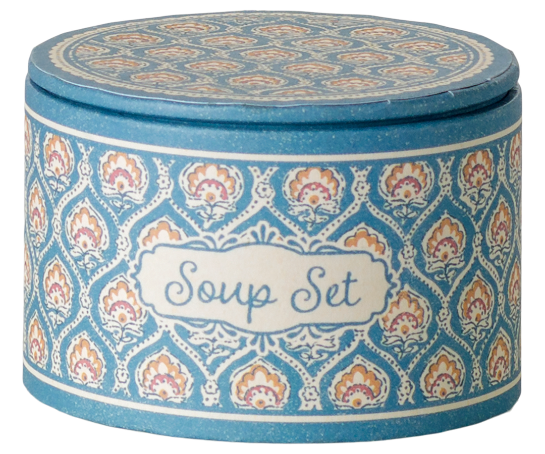 A round lidded container labeled 'Soup Set' with a blue, white, and orange patterned design.