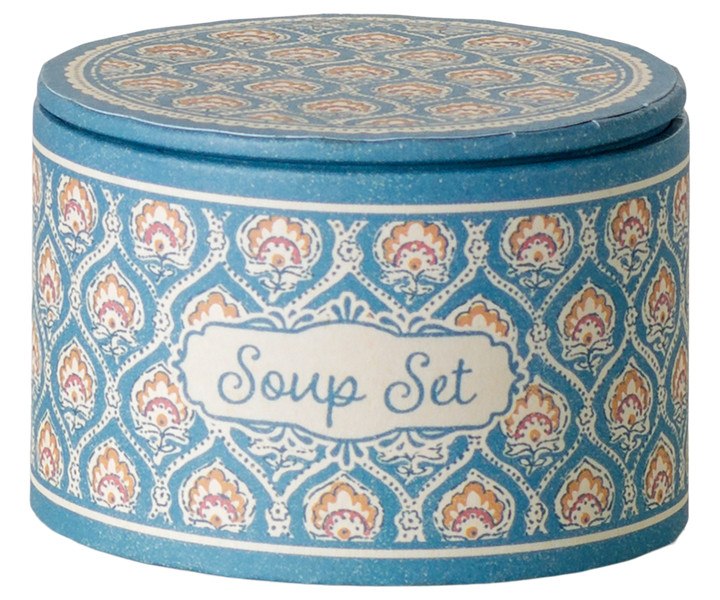 A round lidded container labeled 'Soup Set' with a blue, white, and orange patterned design.